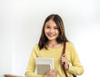 © Katcha - Young woman student is standing and smiling to looking on camera while holding books and bags