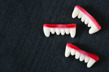 Gummy candy Dracula teeth on a black background with space for copy