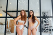 Two young women standing wearing lingerie confident look at camera