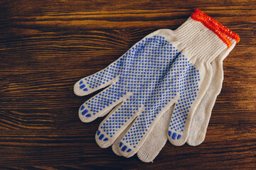 Protective construction gloves on a wooden background. Top view, flat lay.