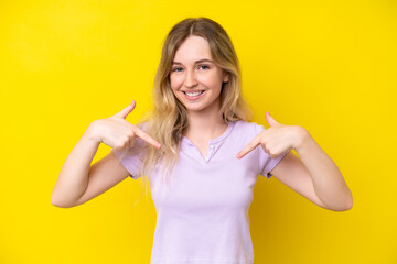 Wall Mural - Blonde English young girl isolated on yellow background proud and self-satisfied