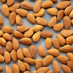 Raw brown almonds on a gray surface, top view. Flat lay, overhead, from above.