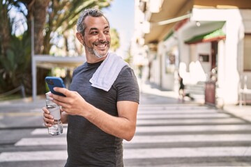 Sticker - Middle age hispanic man wearing sportswear using smartphone at street