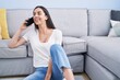 © Krakenimages.com - Young hispanic woman talking on the smartphone sitting on floor at home