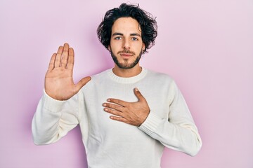 Canvas Print - Handsome hispanic man wearing casual white sweater swearing with hand on chest and open palm, making a loyalty promise oath