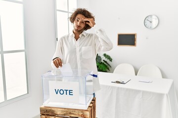 Sticker - Young hispanic man voting putting envelop in ballot box worried and stressed about a problem with hand on forehead, nervous and anxious for crisis