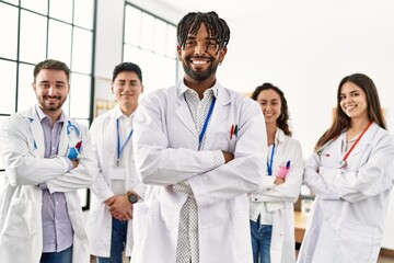 Sticker - Group of young doctor smiling happy standing with arms crossed gesture at the clinic office.