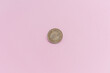 Moneda china de 10 yuanes, sobre un fondo rosa.