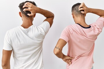 Canvas Print - Young gay couple standing over isolated background backwards thinking about doubt with hand on head