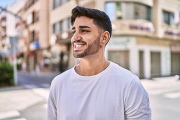 Wall Mural - Handsome hispanic man smiling happy outdoors