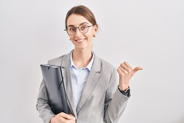 Sticker - Young caucasian woman wearing business clothes and glasses pointing to the back behind with hand and thumbs up, smiling confident