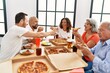 © Krakenimages.com - Group of middle age people smiling happy eating italian pizza sitting on the table at home