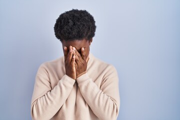 Sticker - African american woman standing over blue background with sad expression covering face with hands while crying. depression concept.