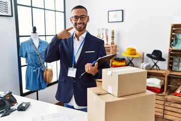 Sticker - African american man working as manager at retail boutique smiling cheerful showing and pointing with fingers teeth and mouth. dental health concept.