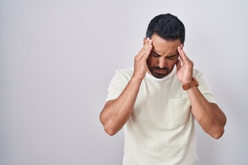 Sticker - Hispanic man with beard standing over isolated background with hand on head, headache because stress. suffering migraine.