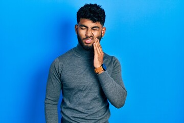 Poster - Arab man with beard wearing turtleneck sweater touching mouth with hand with painful expression because of toothache or dental illness on teeth. dentist