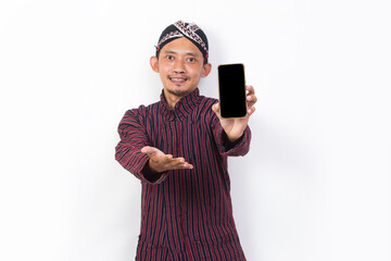 Wall Mural - asian man with javanese traditional cloth lurik demonstrating mobile cell phone isolated on white background