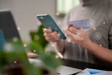 Close up shot of females hands holding credit card typing message on smart phone with technology icons for shopping online.