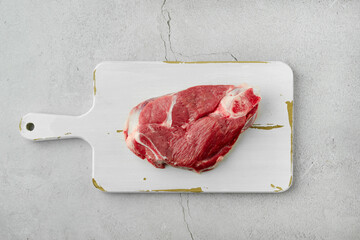 Wall Mural - Overhead view of raw lamb leg cut as a steak on cutting board