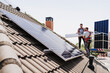 © Westend61 - Electricians installing solar panels on rooftop