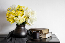 Studio Shot Of Vase With Blooming Daffodils Standing On Rustic Table