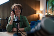 © Westend61 - Happy presenter wearing headset recording podcast in radio station