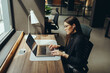 © Jacob Lund - Focused businesswoman using a laptop in a coworking office