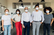 © Westend61 - Coworkers wearing protective face mask standing together in office