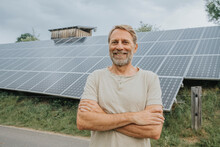Smiling Man Standing In Front Of Solar Panels