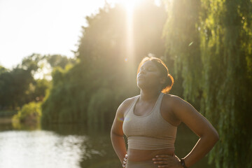 Wall Mural - Young African American woman breathing after hard workout at the park