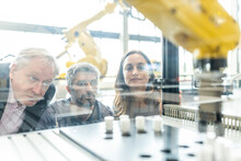 Technicians Testing And Observing New Industrial Robot