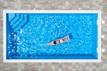 Woman Lying On Raft In Swimming Pool