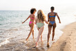 © Westend61 - Carefree multiracial friends running on shore at beach