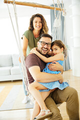 Wall Mural - child daughter family happy mother father sofa playing fun together girl cheerful smiling home indoor