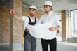 © Serhii - Construction concept of Engineer and Architect working at Construction Site with blue print.