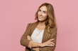 © ViDi Studio - Young smiling happy successful employee business woman 30s she wearing casual brown classic jacket hold hands crossed folded look camera isolated on plain pastel light pink background studio portrait.