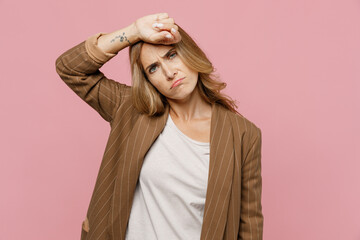 Young sick ill tired sad stressed exhausted employee business woman 30s she wearing casual classic jacket put hand on head suffer from headache isolated on plain pastel light pink background studio.