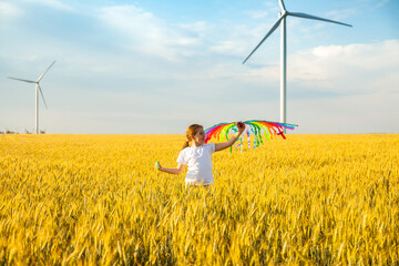 Wall Mural - Happy Little girl running in a wheat field with a kite in the summer.