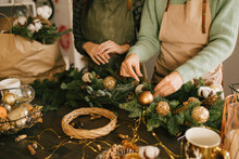 Two Millennial Women Making Christmas Wreath Using Pine Branches And Festive Decorations. Small Business