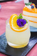A glass of Japanese iced yuzu fruit tea topped with sliced yuzu orange and mint.