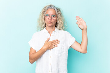 middle age caucasian woman isolated on blue background taking an oath, putting hand on chest.