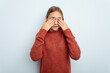 Young caucasian girl isolated on blue background afraid covering eyes with hands.