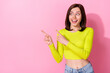 Leinwandbild Motiv Photo of funny dreamy girl dressed lime shirt looking pointing two fingers empty space isolated pink color background