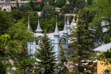 The blue historical building of the Lermontov Gallery in the flower garden park on a cloudy summer day among green trees and flowerbeds