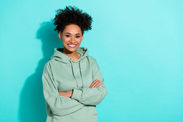 Wall Mural - Portrait of cheerful charming lady crossed arms toothy smile empty space isolated on turquoise color background