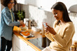 © Drobot Dean - Black girl using mobile phone during spending time with her mother