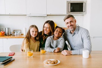 Wall Mural - Happy smiling family sitting at the kitchen table at home