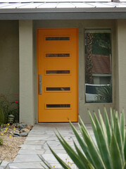 porch of modern home with bright orange front door