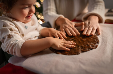 Poster - family, cooking and winter holidays concept - happy mother and baby daughter having fun with dough for gingerbread cookies at home on christmas