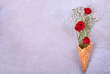 Waffle Ice Cream Cone With Flowers And Copy Space. Red Roses And Tiny White Flowers.
